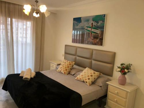 マルベーリャにあるMarina Banusのベッドルーム1室(大型ベッド1台、枕付)、絵画