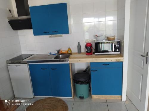 拉蒂爾巴勒的住宿－Appartement bord de mer，一间小厨房,内配蓝色橱柜和微波炉