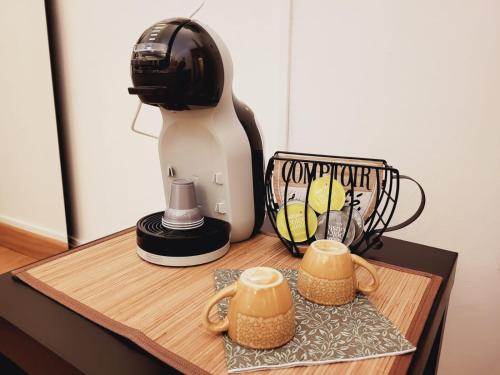 a mixer sitting on a wooden table with two cups at La Perla Di Noto in Noto