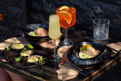 a table with two plates of food and a drink at Almacruz Hotel y Centro de Convenciones (Ex Galerías) in Santiago