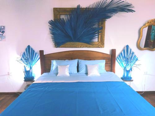 1 dormitorio con 1 cama azul y 2 plantas azules en Blue Palm Resort Ghana, en Abia