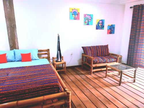 a bedroom with a bed and a couch and a chair at Blue Palm Resort Ghana in Abia