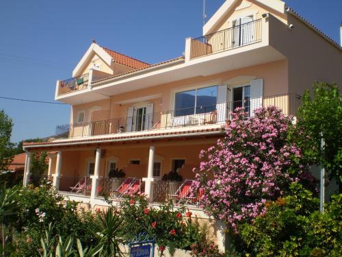 a large house with a balcony and pink flowers at Anna Studios in Zóla