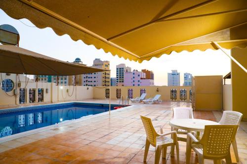 a patio with a table and chairs and a pool at Pearl Bahrain WLL in Manama