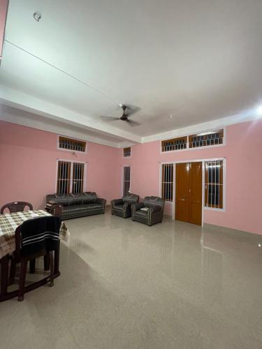 a living room with pink walls and couches and a table at MriMan Homestay in Jorhāt