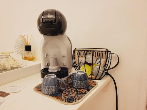a coffee maker and two cups on a counter at La Perla Di Noto in Noto