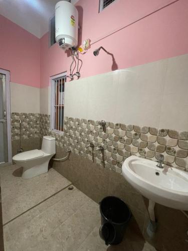 a bathroom with a toilet and a sink at MriMan Homestay in Jorhāt
