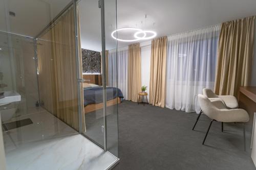 a hotel room with a bed and a glass wall at Hotel Zemplín in Trebišov