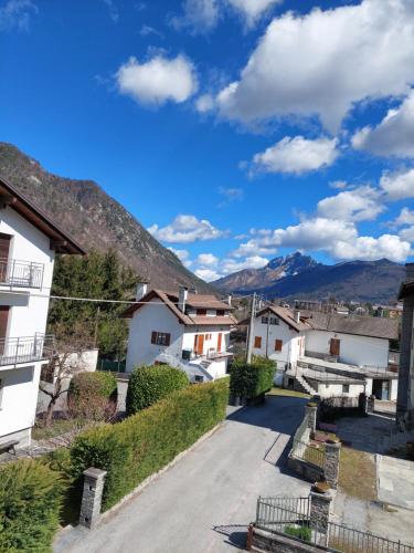 una calle en un pueblo con montañas en el fondo en Casa Pepolina, zona tranquilla, piano terra con parcheggio, en Malesco