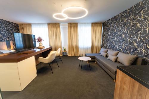a living room with a couch and a desk at Hotel Zemplín in Trebišov