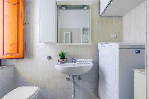 a bathroom with a sink and a toilet and a mirror at Pisa Airport Comfy Apartment - Private Parking in Pisa