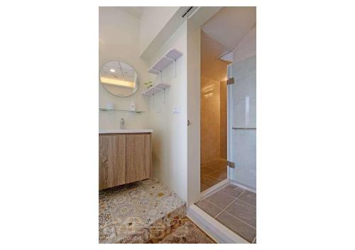 綠島鄉的住宿－綠島紅魔鬼民宿，浴室设有步入式淋浴间,位于玻璃门旁