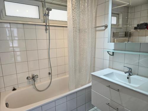 y baño con bañera, lavamanos y ducha. en Komfortables 3-Zimmer Apartment in Schwetzingen zwischen Mannheim und Heidelberg, en Schwetzingen