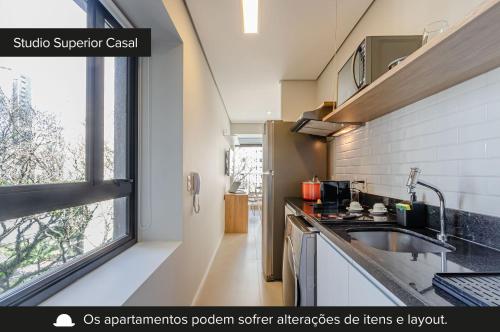 a kitchen with a sink and a large window at Charlie Itaim Bueno Brandão in Sao Paulo