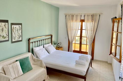 a bedroom with a bed and a couch and a window at Armonia Elegant Apartments in Rovies
