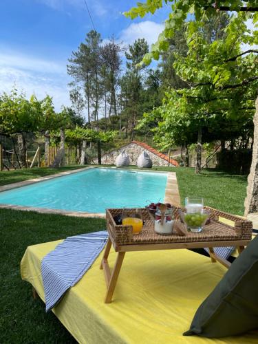 a table with a tray of food next to a swimming pool at Casa de Morão in Viana do Castelo