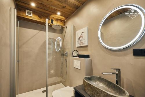 a bathroom with a shower and a sink and a mirror at Chalet Weidentraum in Oberstaufen