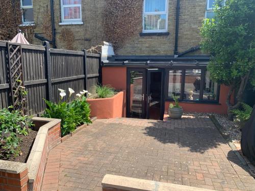 a brick walkway in front of a house with a fence at Margate Escape House, sleeps 5-6. Free parking. in Kent