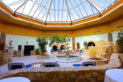 a patio with a fountain and a stone wall at Carea Harz Hotel Allrode in Allrode
