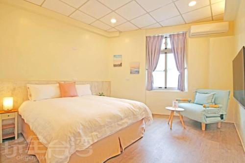 1 dormitorio con 1 cama, 1 silla y 1 ventana en Lu Dao Homestay, en Isla Verde