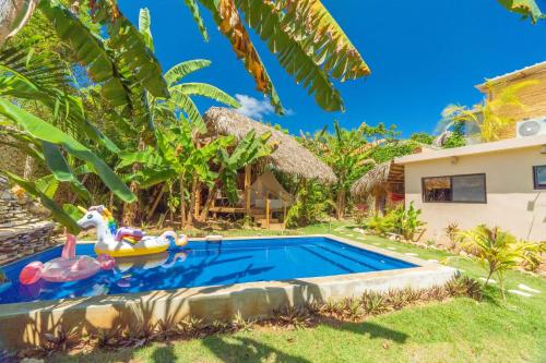 una piscina en el patio trasero de una casa con un flotador en Casita Chinola - Playa El Encuentro, en Bombita