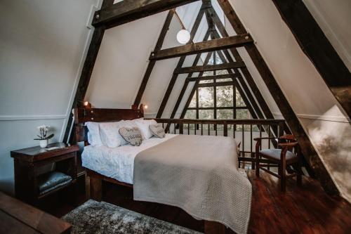 a bedroom with a bed and a large window at Hide Away Cabin in Knysna