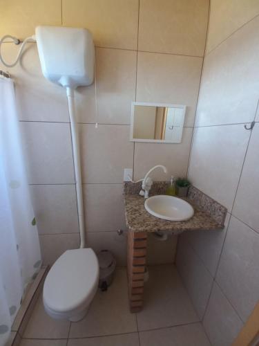 a small bathroom with a toilet and a sink at CASA DE CAMPO RIO CANOAS in Urubici