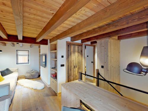 a room with wooden ceilings and a room with a table at Chalet de Luxe à Saint Martin de Belleville : Spa, Sauna, Proche Pistes et Commerces - FR-1-452-199 in Saint-Martin-de-Belleville