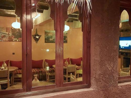 a restaurant with a reflection of a table in a window at Ouirgane discovery lodge in Ouirgane