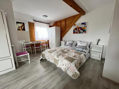 Un dormitorio con una cama y una mesa. en A Festő Vendégháza / The Painter's Guest House, en Zánka