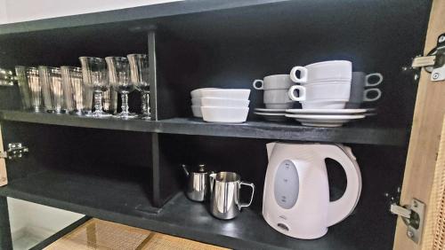 a shelf with cups and dishes on it in a kitchen at San Clemente House in Seville