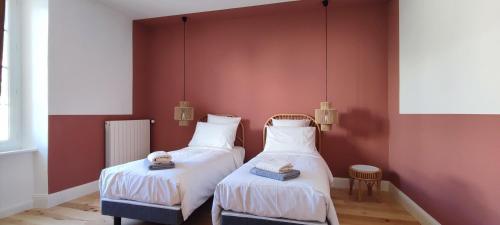 2 camas en una habitación con paredes rojas en L'Oustal de Papet, en Ferrals-lès-Corbières