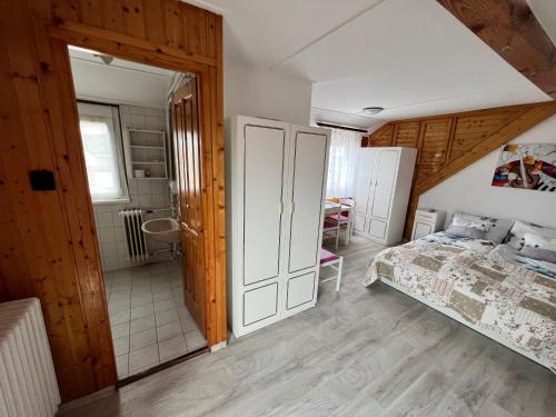 a bedroom with a bed and a bathroom at A Festő Vendégháza / The Painter's Guest House in Zánka