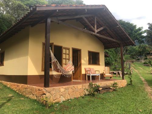a house with a porch with an american flag at Sitio Eco Friends - Perfeita para Casal e Família! in São Bento do Sapucaí