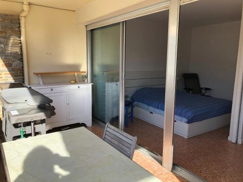 une chambre avec un lit, une table et un miroir dans l'établissement Studio des îles, à Cavalaire-sur-Mer