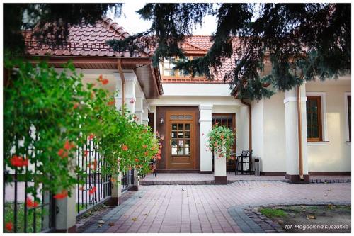 a house with a brick walkway leading to a door at Restauracja Ambrozja i Pokoje gościnne in Mława