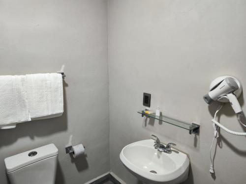 a white bathroom with a toilet and a sink at Suite privada in San Martín de las Pirámides