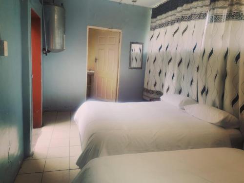 克魯格斯多普的住宿－Stay Inn Krugersdorp，卧室配有两张白色的床。