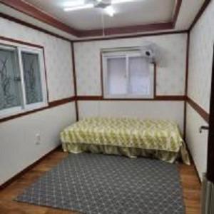 a small room with a bed and a window at Hongcheon fence house in Hongcheon