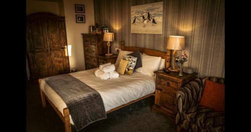 Ensuite Bed And Breakfast Rooms At The Ring Pub في Gwredog: غرفة نوم عليها سرير وفوط