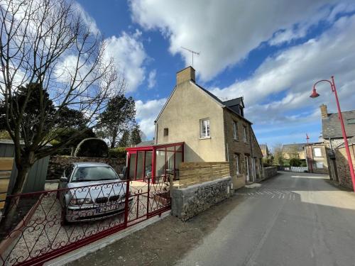 a car parked in front of a building on a street at Le Marlo in Poilley