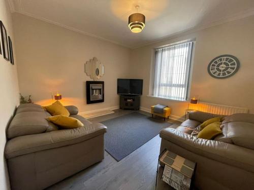 a living room with two couches and a television at Newly Renovated Oliver Apartment in Hawick
