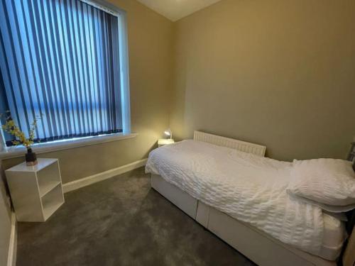 a bedroom with a white bed and a window at Newly Renovated Oliver Apartment in Hawick