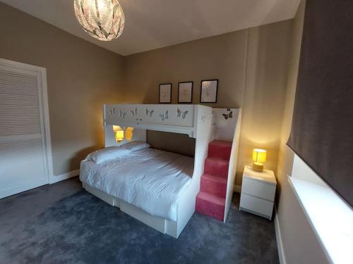 a bedroom with a white bed and a chandelier at Newly Renovated Oliver Apartment in Hawick