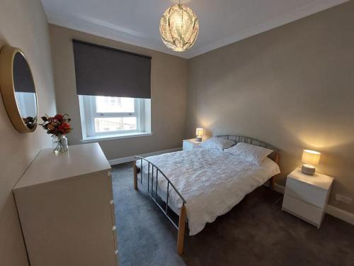 a bedroom with a bed and a window and a mirror at Newly Renovated Oliver Apartment in Hawick