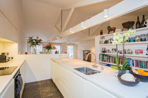 a kitchen with a sink and a counter top at Beautiful Kensington flat in London