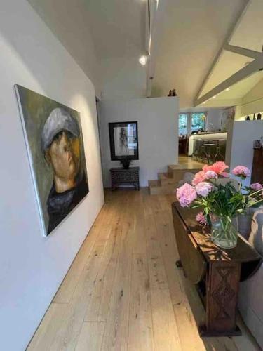 a living room with a painting and flowers on a wall at Beautiful Kensington flat in London