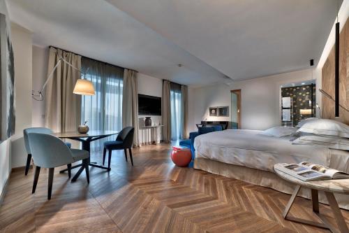 a hotel room with a large bed and a desk at Esplanade Tergesteo - Luxury Retreat in Montegrotto Terme