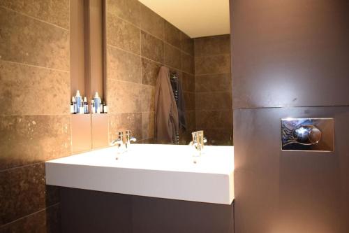 a bathroom with a sink and a refrigerator at Beautiful Kensington flat in London