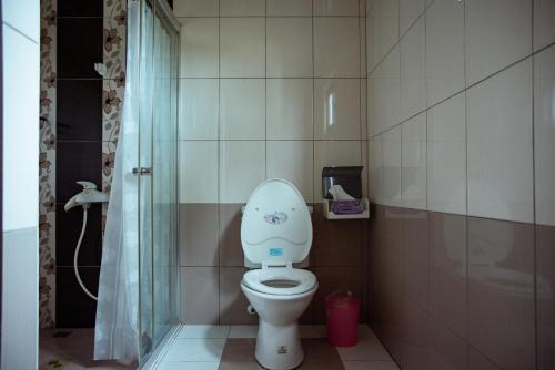 a small bathroom with a toilet and a shower at Bare Foot Diving Hostel 2 in Hengchun